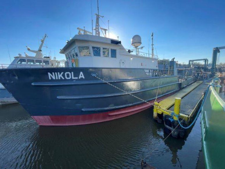 The M/V Nikola moored under a clear northern sky